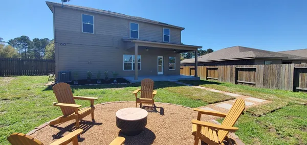 a view of a house with a yard patio and a small yard