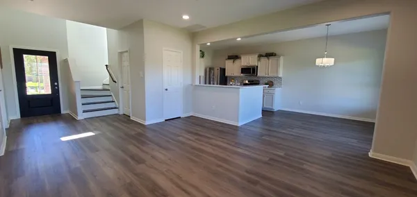 a view of kitchen center island wooden floor and stainless steel appliances