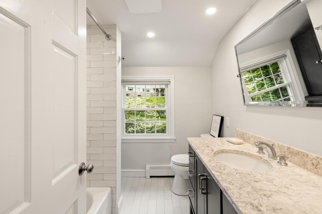 105 Thornberry Road Winchester, MA 01890 - Photo 23 of 35 a bathroom with a granite countertop sink a toilet and a window