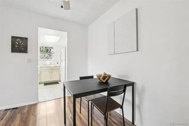 a view of a workspace room with wooden floor and dining table