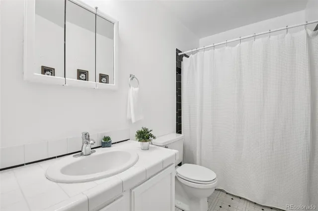 a bathroom with a sink toilet and a mirror