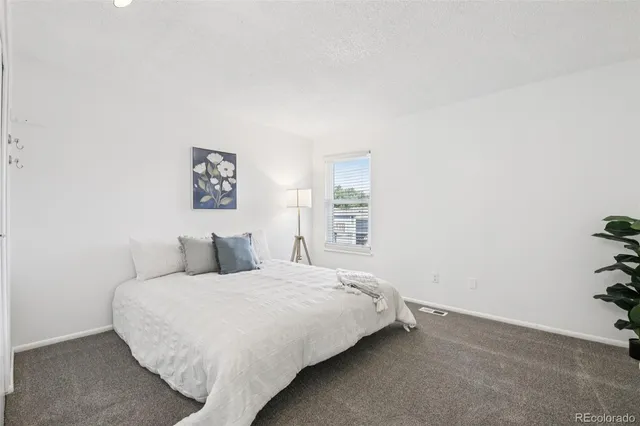 a bedroom with a bed and a potted plant