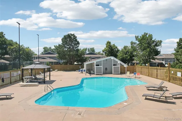 a view of a house with pool and chairs