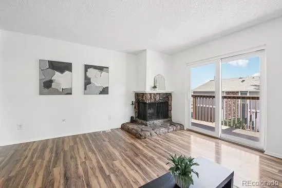 a view of a livingroom with wooden floor and furniture