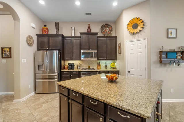 a kitchen with stainless steel appliances granite countertop a refrigerator and stove