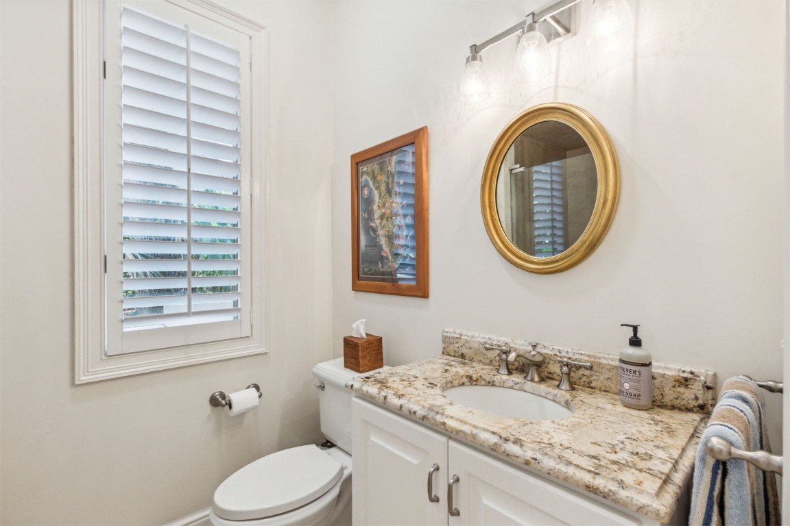 10 Marsh Creek Road Amelia Island, FL 32034 - Photo 18 of 73 a bathroom with a granite countertop toilet a sink and a mirror