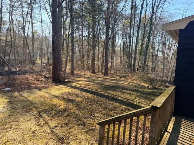 a view of a house with a small yard and wooden fence