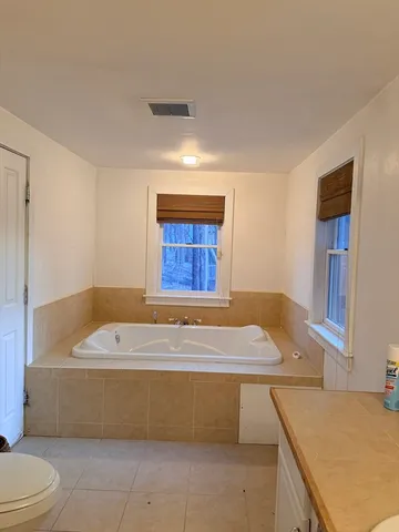 a white bath tub sitting in a bathroom next to a window