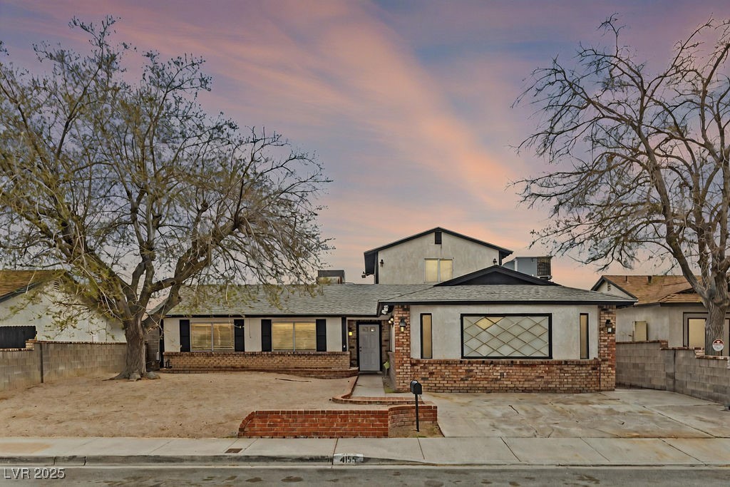View of front of property with brick siding, a shi