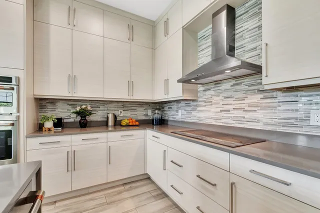 a large kitchen with kitchen island a sink a counter top space and stainless steel appliances