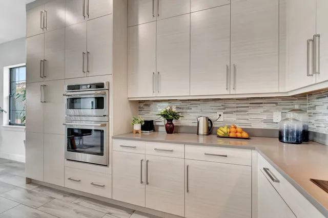 a kitchen with white cabinets and stainless steel appliances