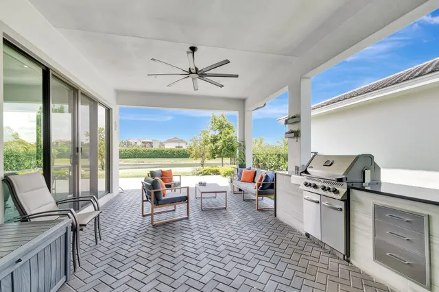 a view of a patio with table and chairs potted plants with floor to ceiling window