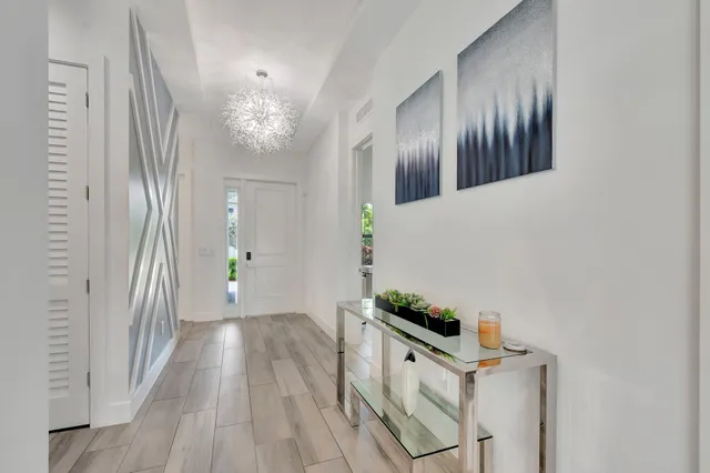 a bedroom with a bed a chandelier and a window