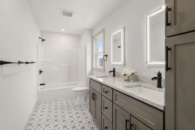 a bathroom with a sink a toilet and shower