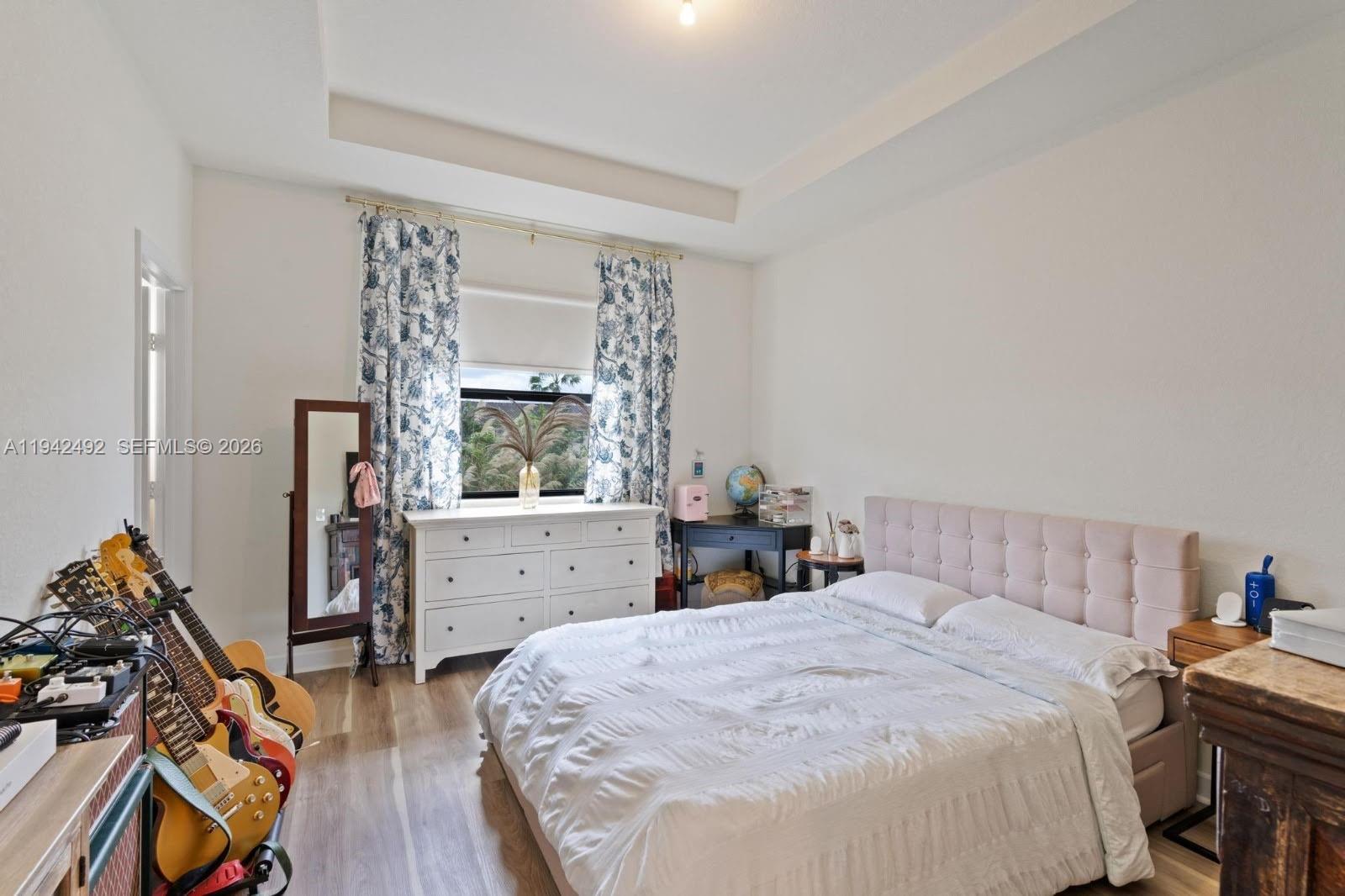 3304 West 92nd Place Hialeah, FL 33018 - Photo 16 of 34 a bedroom with a bed and a dresser next to a window