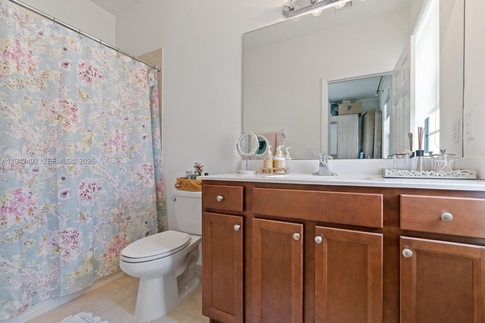 3304 West 92nd Place Hialeah, FL 33018 - Photo 20 of 34 a bathroom with a sink a toilet and shower curtain