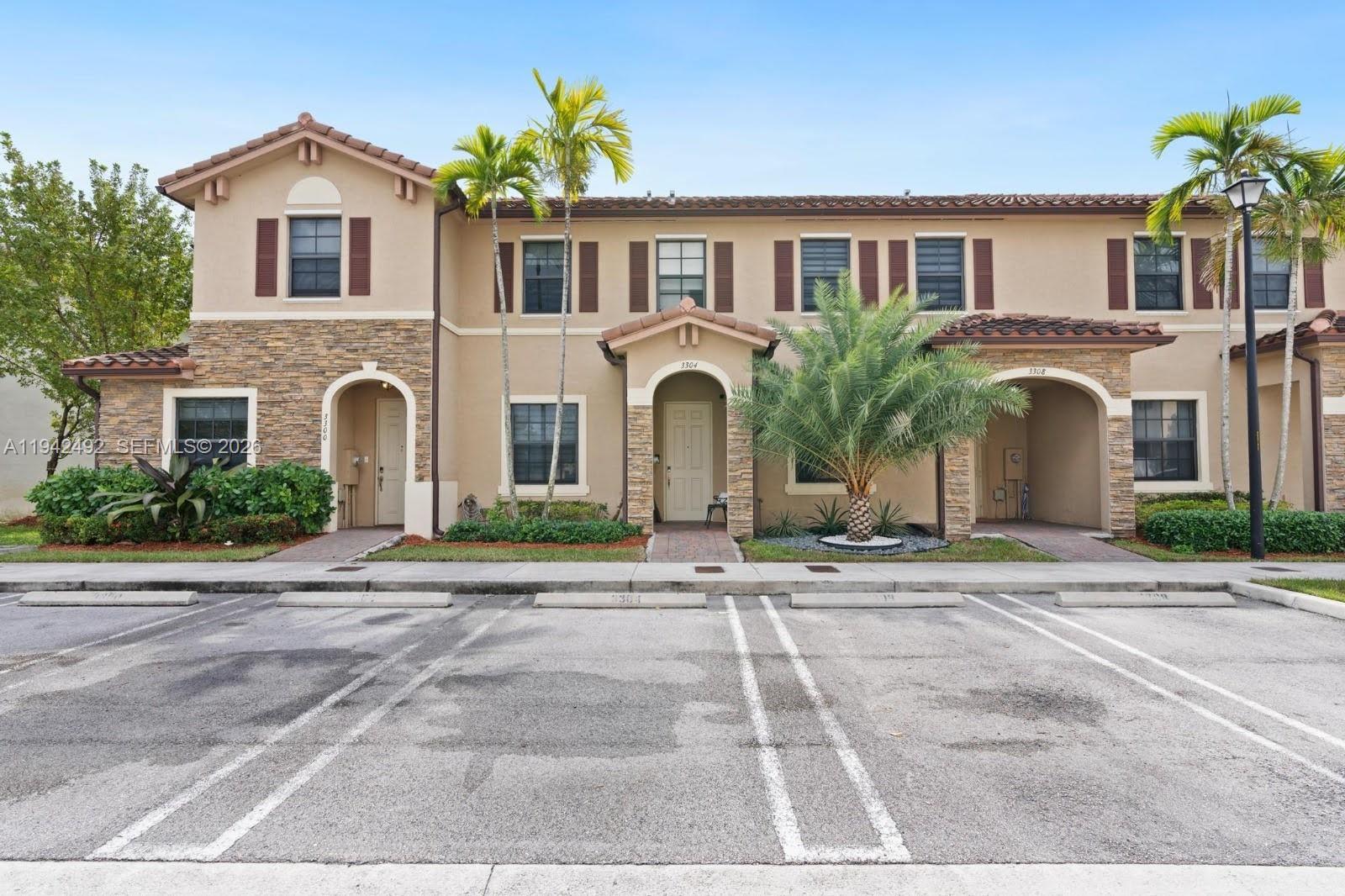 3304 West 92nd Place Hialeah, FL 33018 - Photo 2 of 34 a front view of a house with a yard and a garage