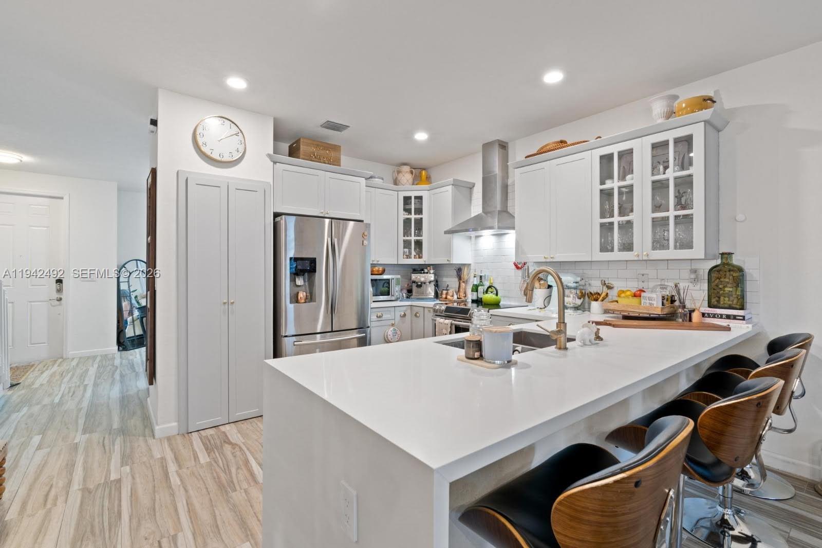 3304 West 92nd Place Hialeah, FL 33018 - Photo 8 of 34 a kitchen with a table chairs refrigerator and cabinets