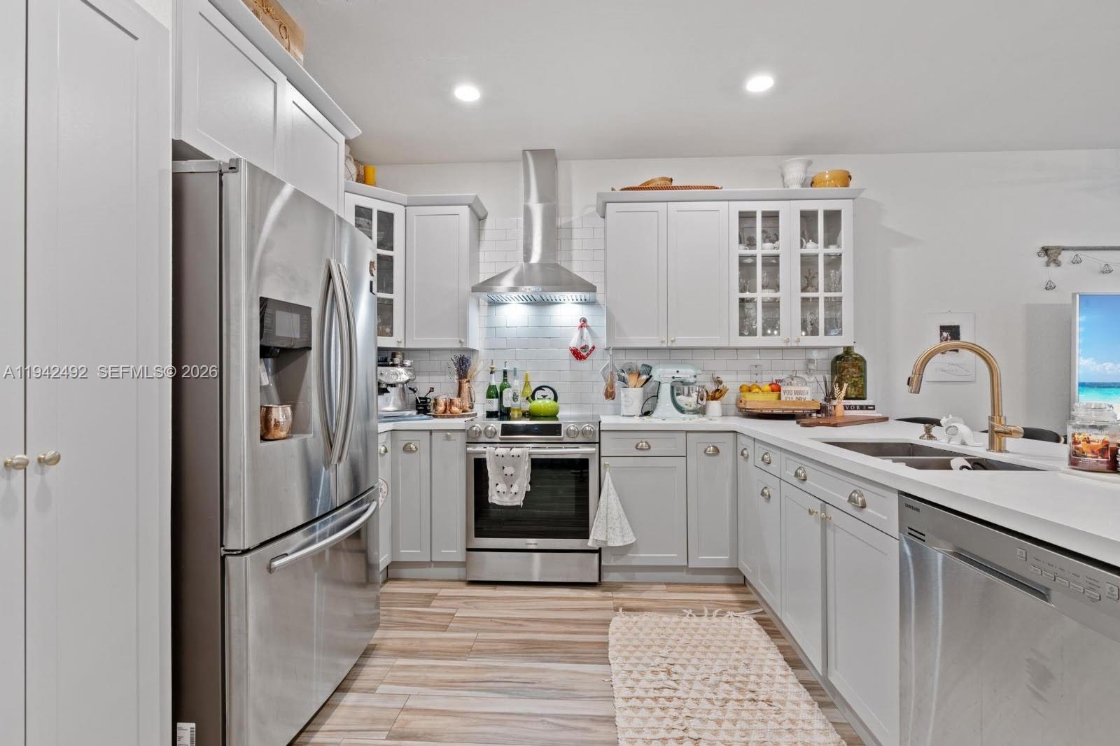 3304 West 92nd Place Hialeah, FL 33018 - Photo 10 of 34 a kitchen with stainless steel appliances granite countertop a refrigerator sink and white cabinets