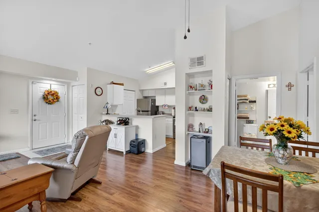 a living room with furniture wooden floor and a kitchen view