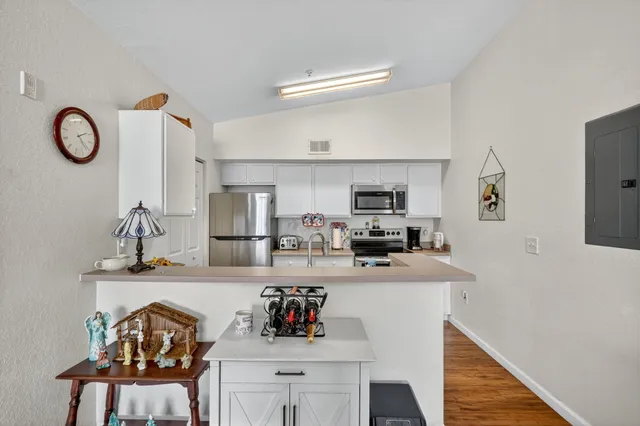 a kitchen with stainless steel appliances granite countertop a sink and a stove with white countertops