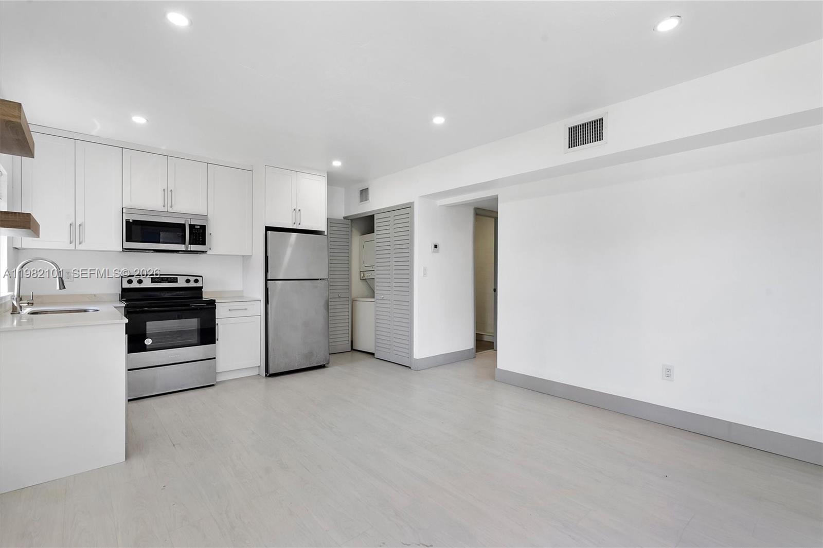 775 Northwest 96th Street, Unit B Miami, FL 33150 - Photo 2 of 9 a kitchen with stainless steel appliances a refrigerator and a stove top oven