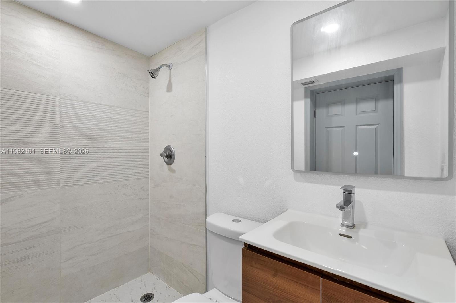775 Northwest 96th Street, Unit B Miami, FL 33150 - Photo 7 of 9 a bathroom with a sink a mirror and shower