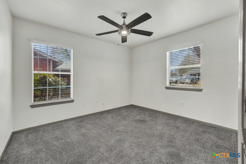 313 Armstrong Street San Marcos, TX 78666 - Photo 12 of 25 an empty room with ceiling fan and windows