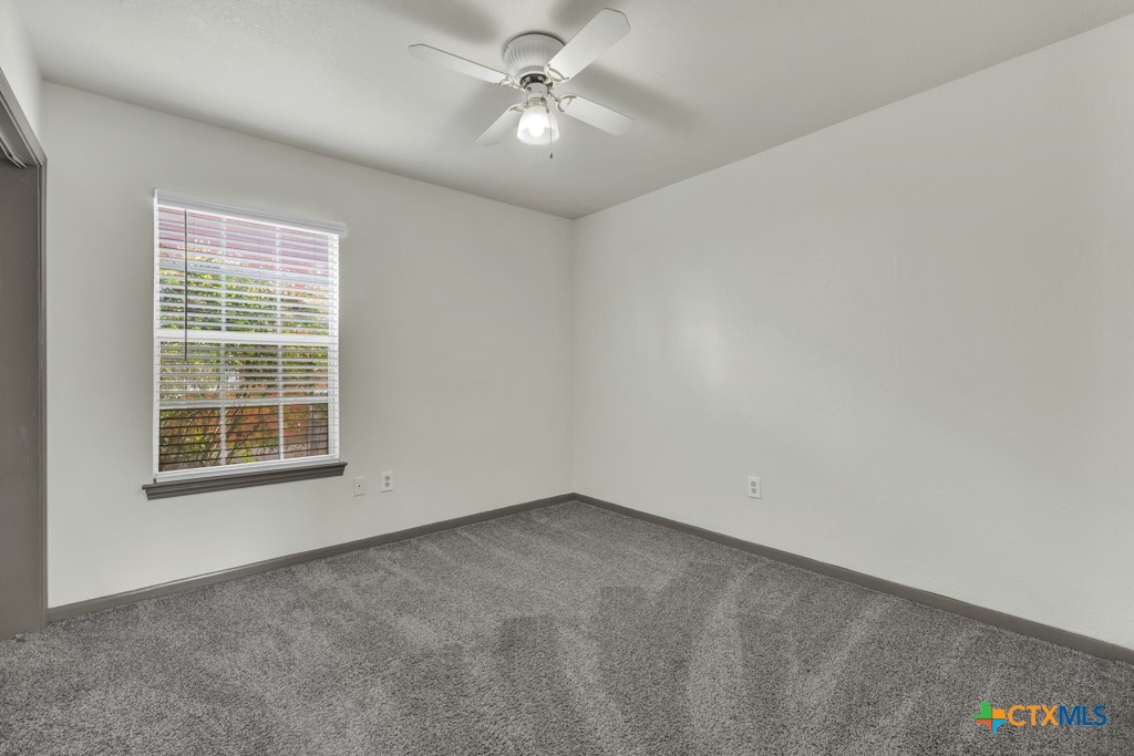 313 Armstrong Street San Marcos, TX 78666 - Photo 15 of 25 an empty room with a window and a ceiling fan