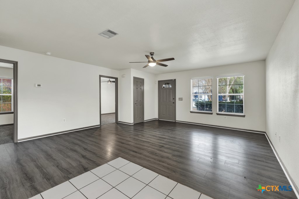 313 Armstrong Street San Marcos, TX 78666 - Photo 4 of 25 a view of an empty room with wooden floor and a window