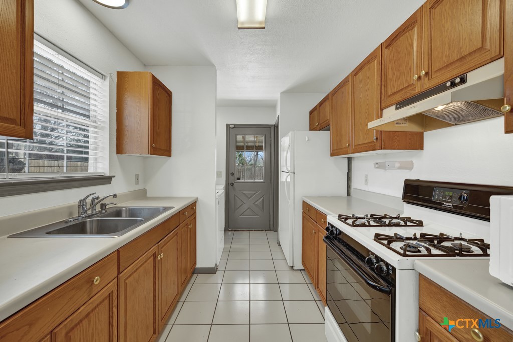 313 Armstrong Street San Marcos, TX 78666 - Photo 9 of 25 a kitchen with stainless steel appliances a sink a stove and a refrigerator