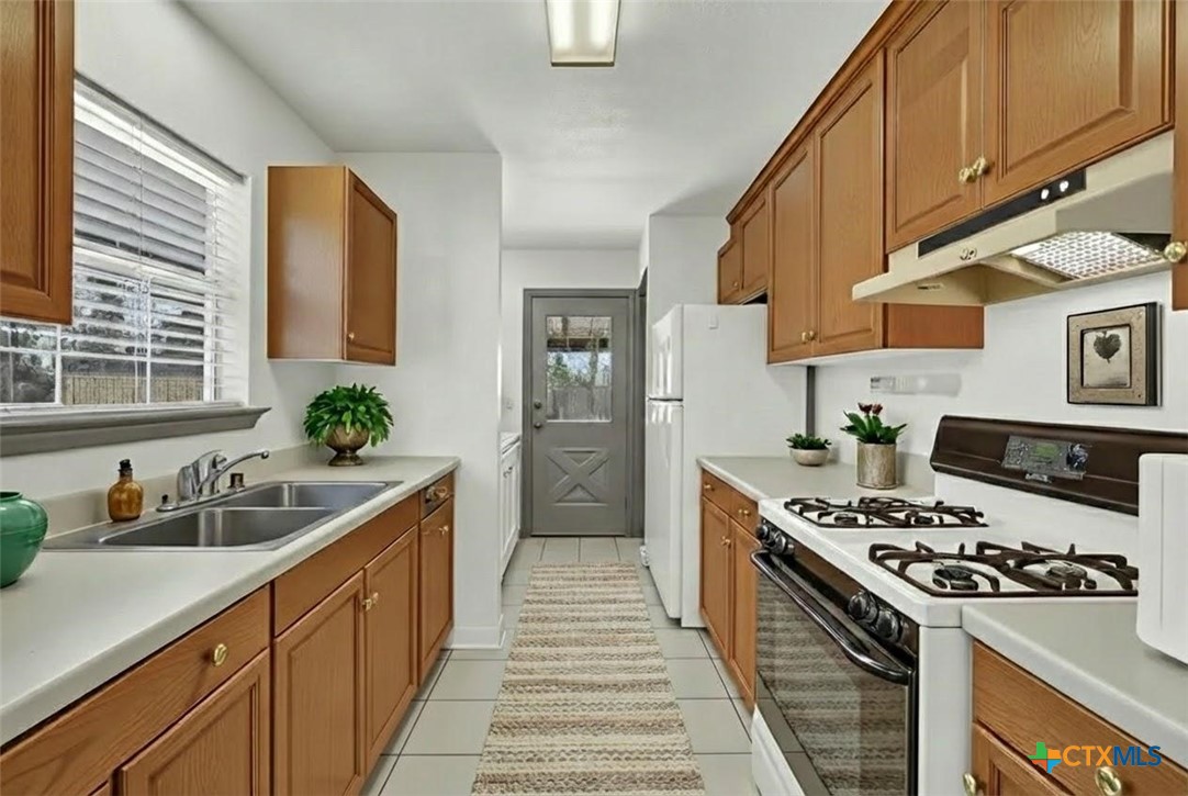 313 Armstrong Street San Marcos, TX 78666 - Photo 10 of 25 a kitchen with stainless steel appliances a sink a stove and cabinets