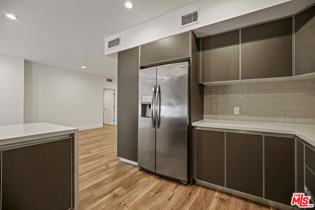 a view of a refrigerator in kitchen and wooden floor