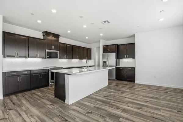 a large kitchen with stainless steel appliances kitchen island granite countertop a stove and a sink