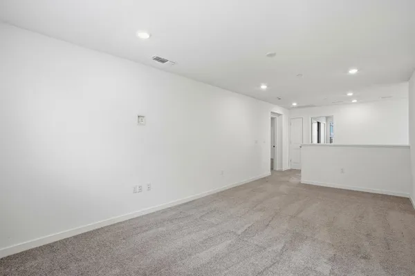 an empty room with white walls and windows