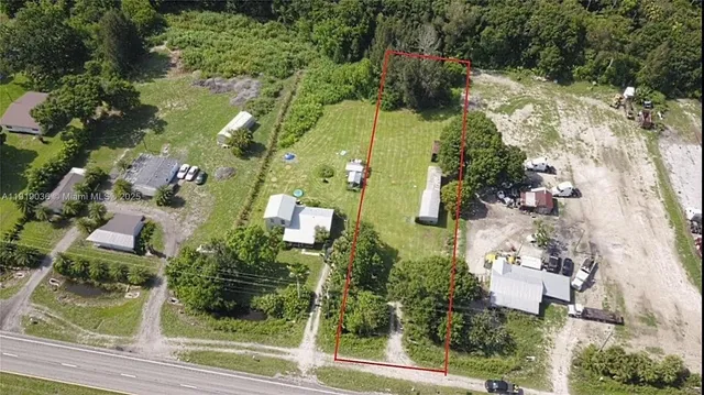 an aerial view of residential houses with outdoor space and trees