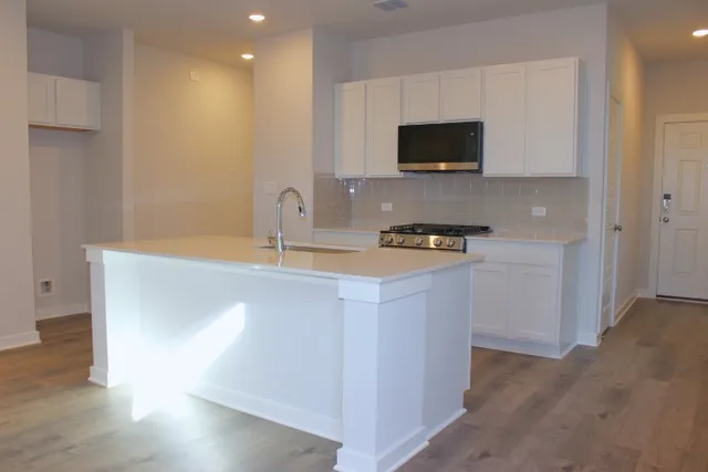 a kitchen with stainless steel appliances a microwave a sink and a stove