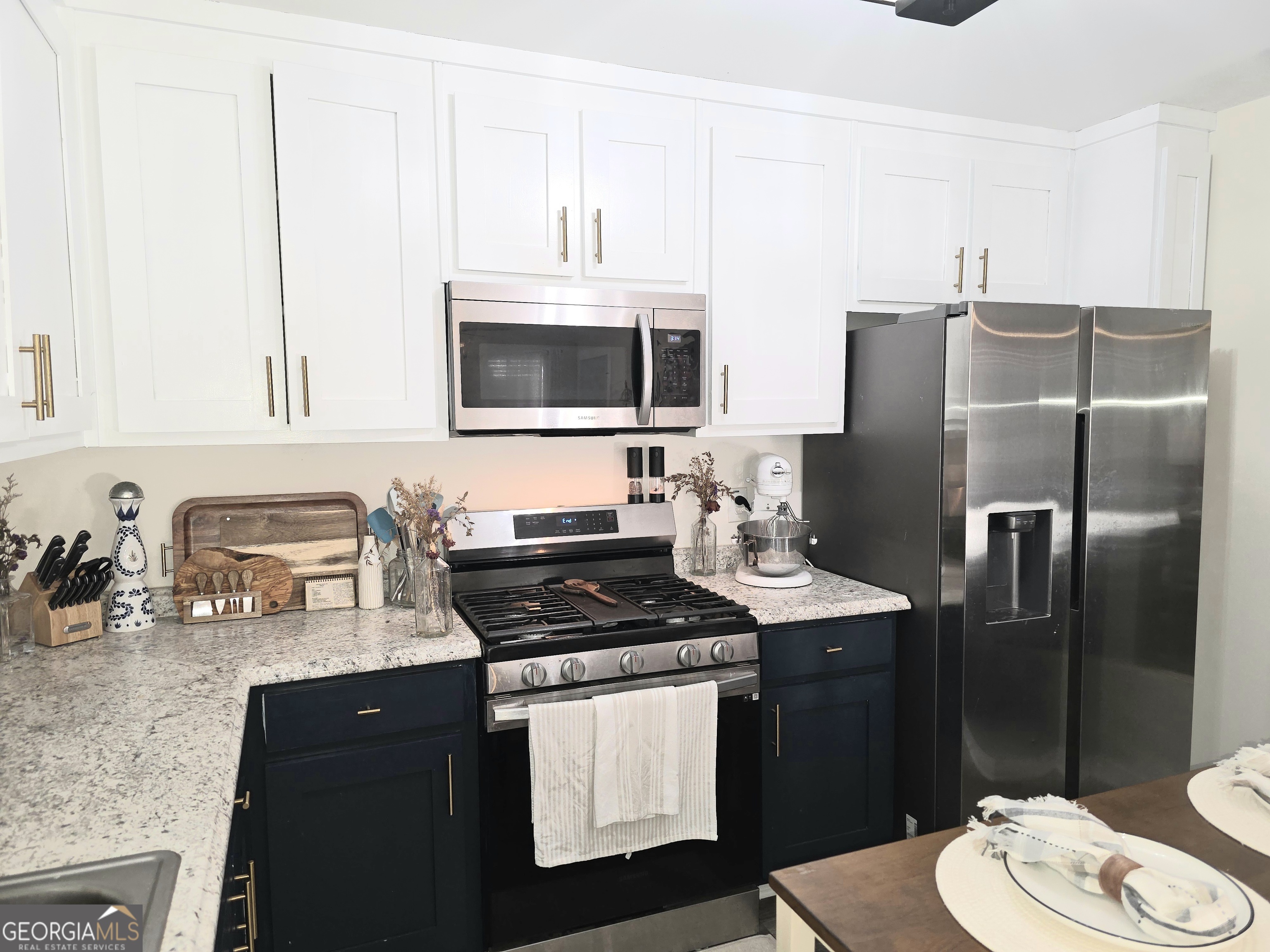 3060 Eatonton Road Madison, GA 30650 - Photo 54 of 65 a kitchen with stainless steel appliances a stove a sink a refrigerator white cabinets and wooden floor