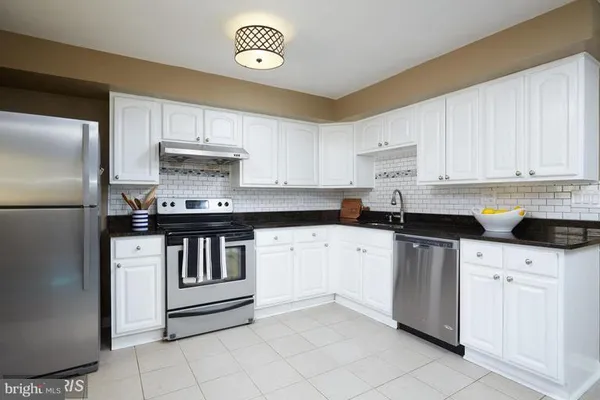 a kitchen with stainless steel appliances granite countertop a refrigerator sink and cabinets