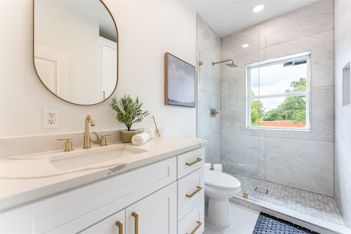 12605 Fitzhugh Road Austin, TX 78736 - Photo 21 of 40 a bathroom with a double vanity sink toilet mirror and shower