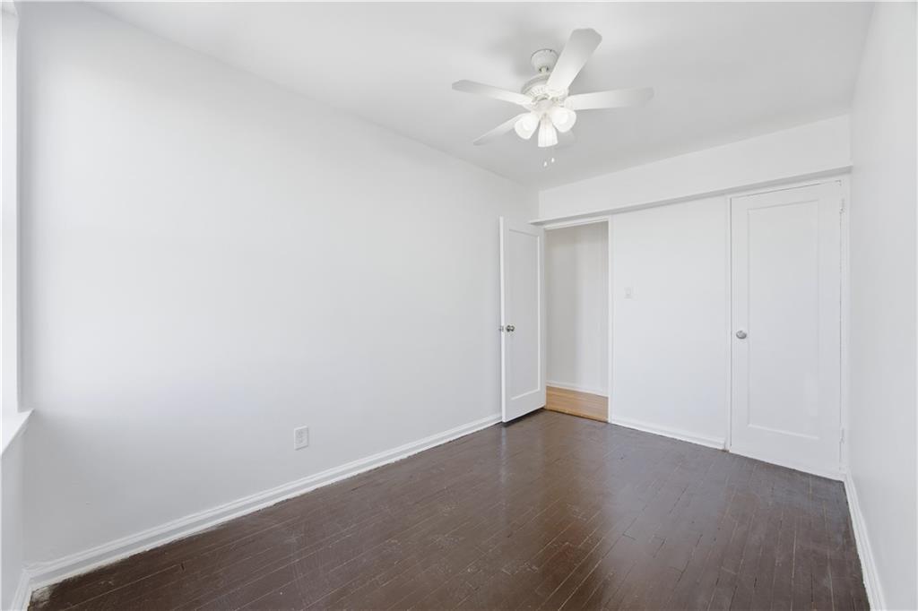 302 96th Street, Unit 3H Brooklyn, NY 11209 - Photo 11 of 14 an empty room with wooden floor and fan