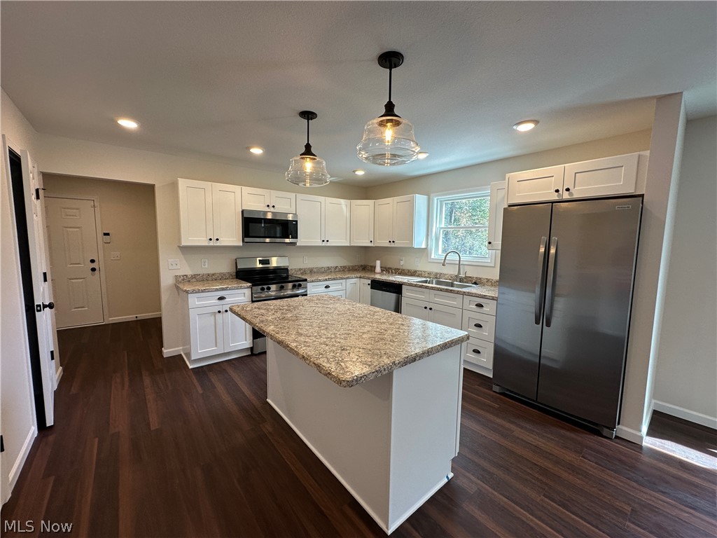 363 Sexton Street Struthers, OH 44471 - Photo 8 of 20 Modern kitchen featuring white cabinetry, laminate countertops, stainless steel appliances, and LTV flooring throughout the open layout