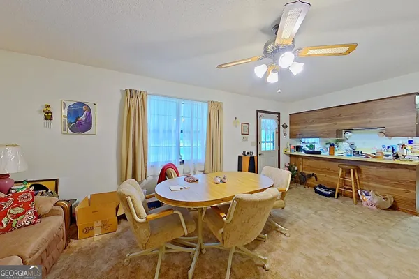 a dining room with furniture and a kitchen view