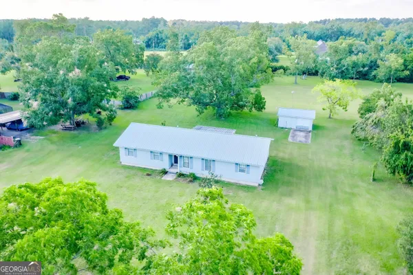 an aerial view of a house with pool a yard and a fountain