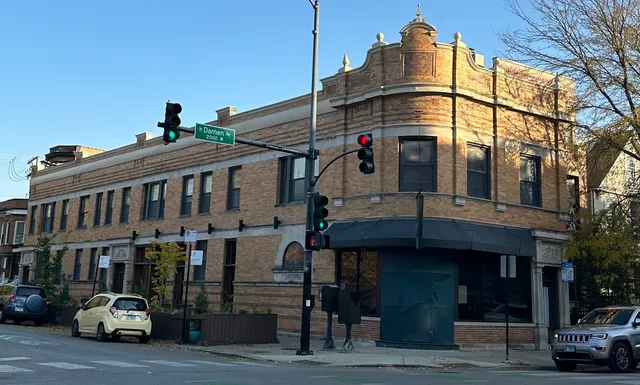 a front view of a building and car parked