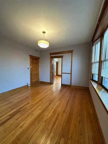 a view of a room with wooden floor and a window