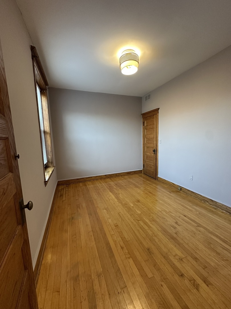 3759 North Damen Avenue, Unit 2 Chicago, IL 60613 - Photo 15 of 22 an empty room with wooden floor and windows