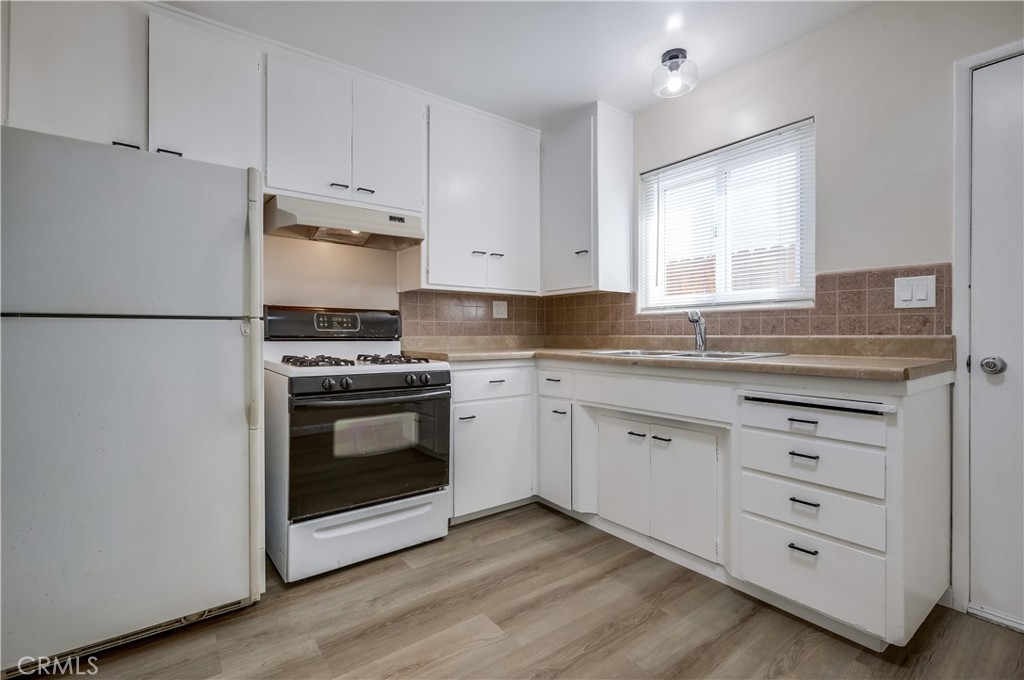 142 Avenida Pelayo, Unit B San Clemente, CA 92672 - Photo 11 of 26 a kitchen with granite countertop white cabinets and white appliances