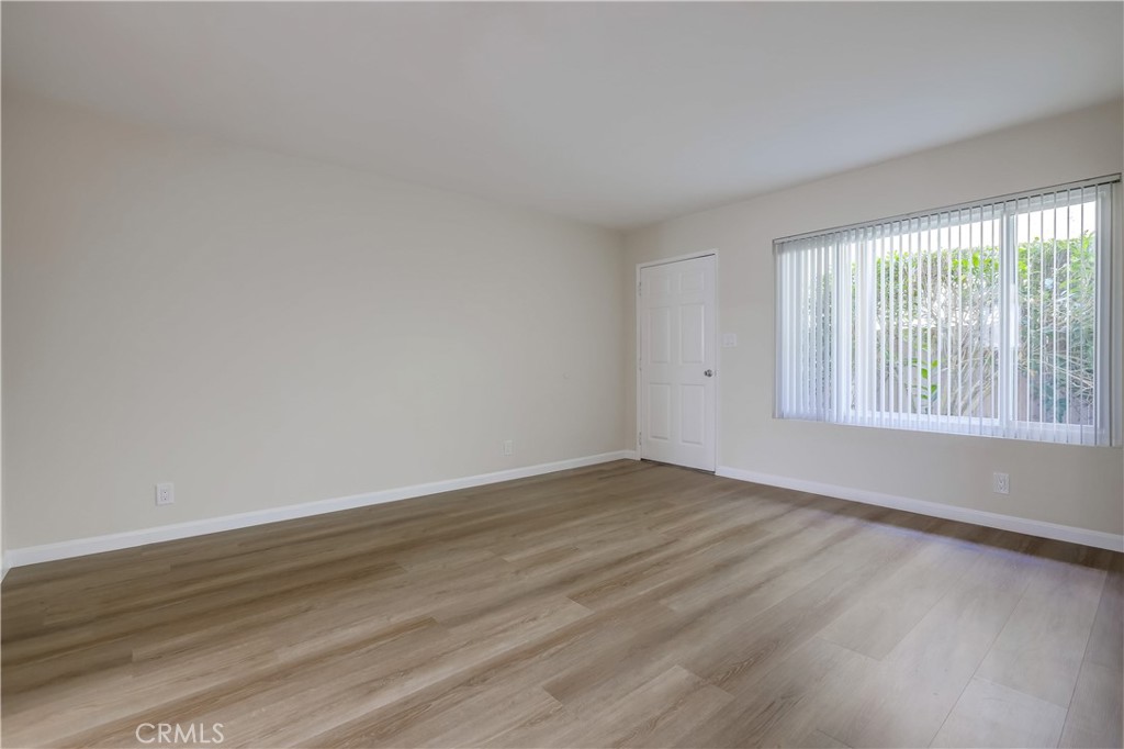 142 Avenida Pelayo, Unit B San Clemente, CA 92672 - Photo 6 of 26 a view of an empty room with wooden floor and a window