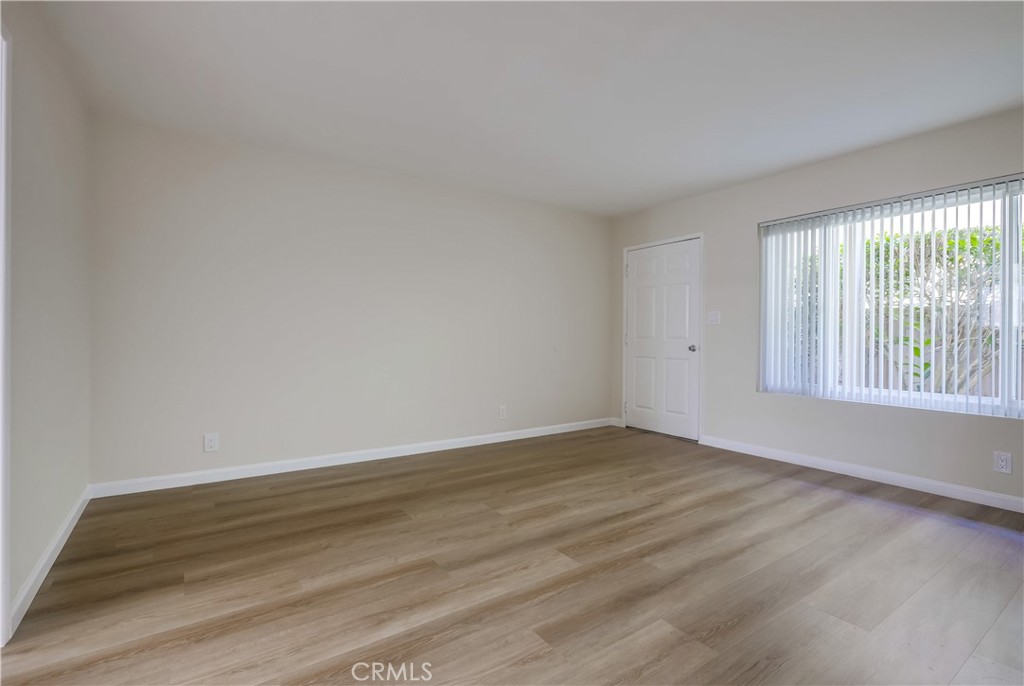 142 Avenida Pelayo, Unit B San Clemente, CA 92672 - Photo 7 of 26 a view of an empty room with wooden floor and a window